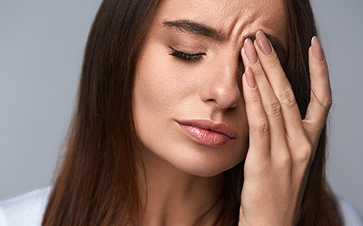 Woman holding her face in pain