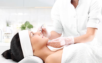 Woman laying down with a doctor looking at her face