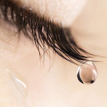 Closeup of a tear coming from an eye