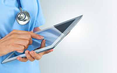Doctor looking and pointing at a tablet computer
